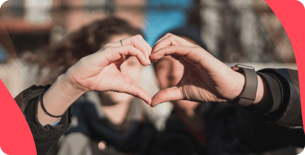 Two people making a heart shape with their hands combined.