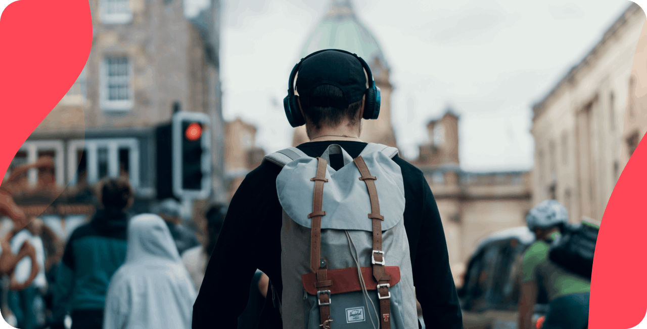 Man walking down the street with headphones, illustrating that people still listen to the radio.
